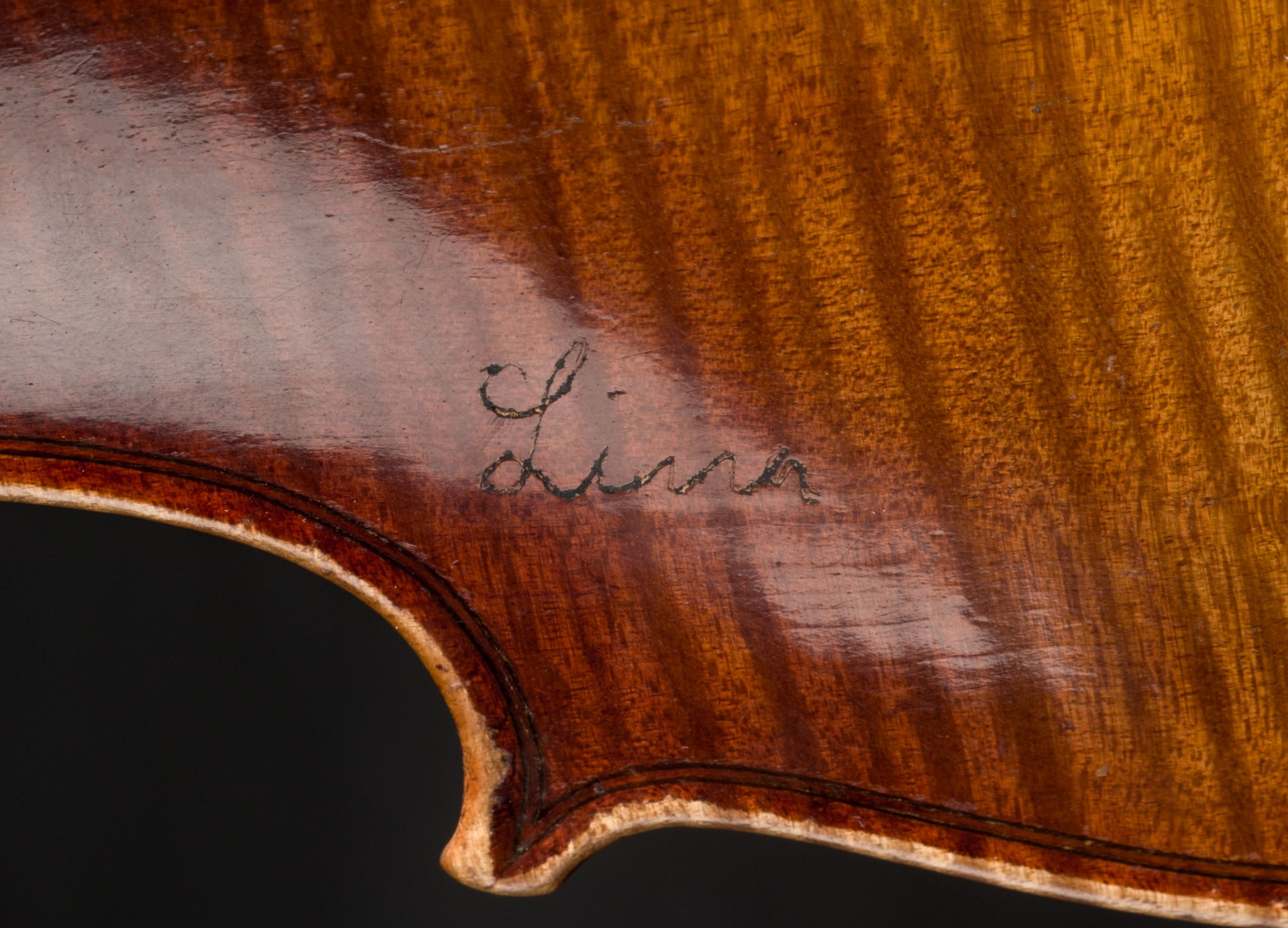 A closeup of Einstein's violin, where the name 'Lina' is etched.