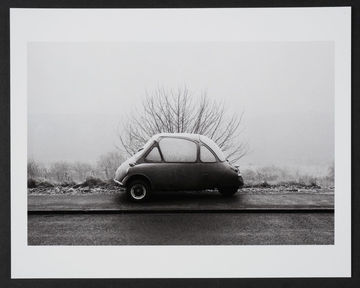 A photograph of a car in a snowy landscape by Martin Parr.