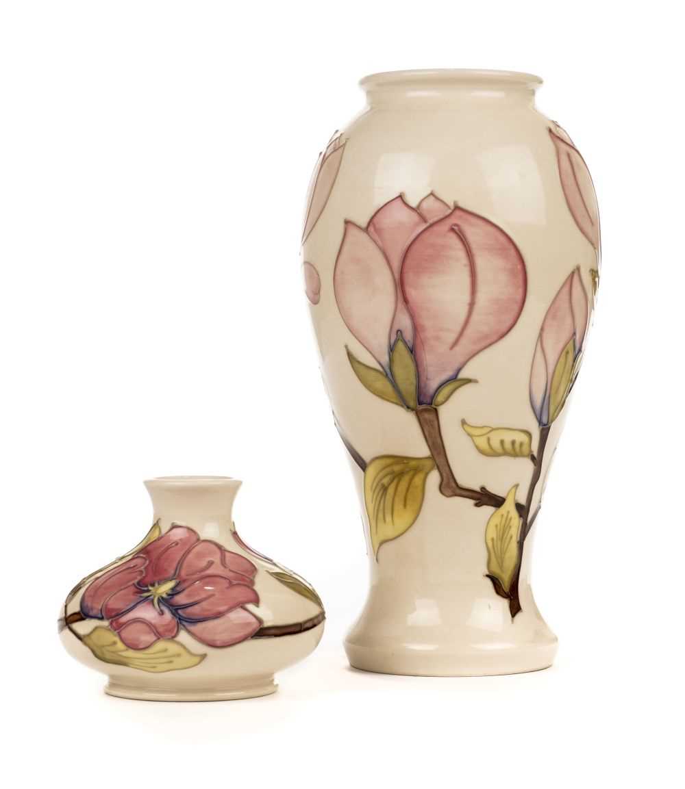 Lot 20 - Moorcroft. A Moorcroft pottery 'Magnolia' pattern vase and two others