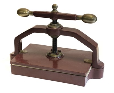 Lot 558 - Bookpress. A cast iron bookpress, finished in red, with brass handle ends & finial