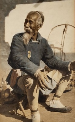 Lot 315 - China. An old man on a boat, hand-coloured carbon print, Tientsin, 1920s