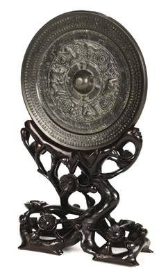 Lot 159 - Chinese. An archaic bronze mirror on a hardwood stand
