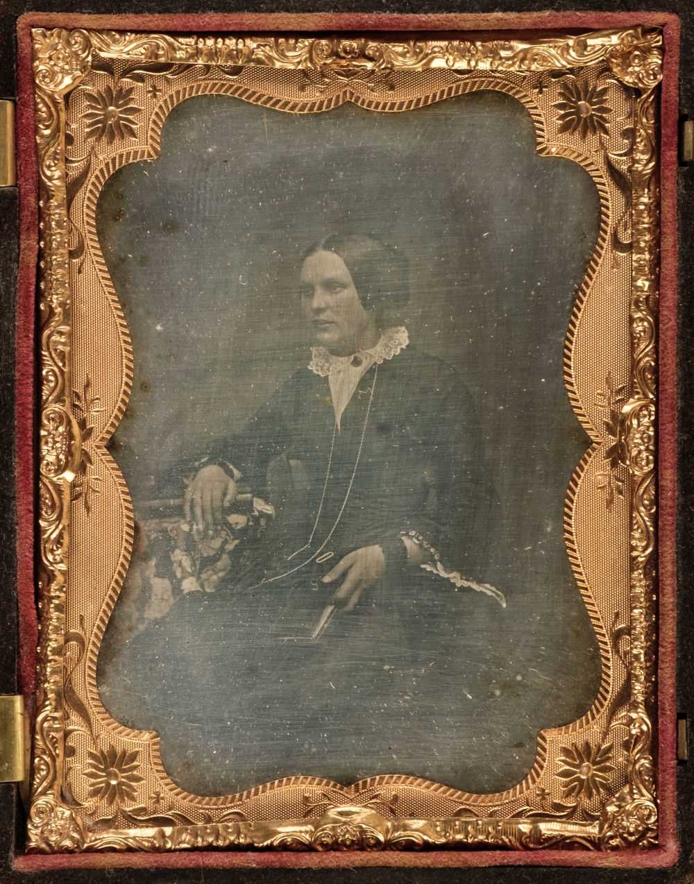 Lot 30 - Daguerreotypes. A one-quarter plate daguerreotype of a seated young woman holding a book, circa 1860