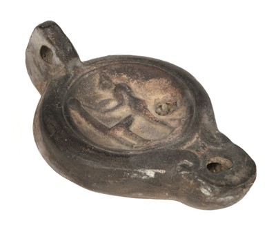 Lot 141 - Roman. A Roman terracotta oil lamp decorated with a naked female washing