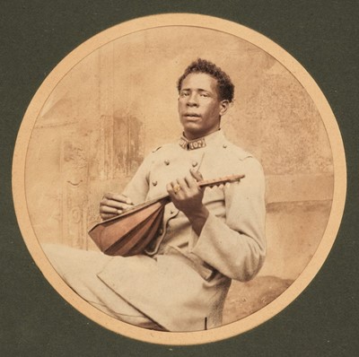 Lot 2 - Africa. Portrait of an African man in French army uniform playing a lute, c. 1890