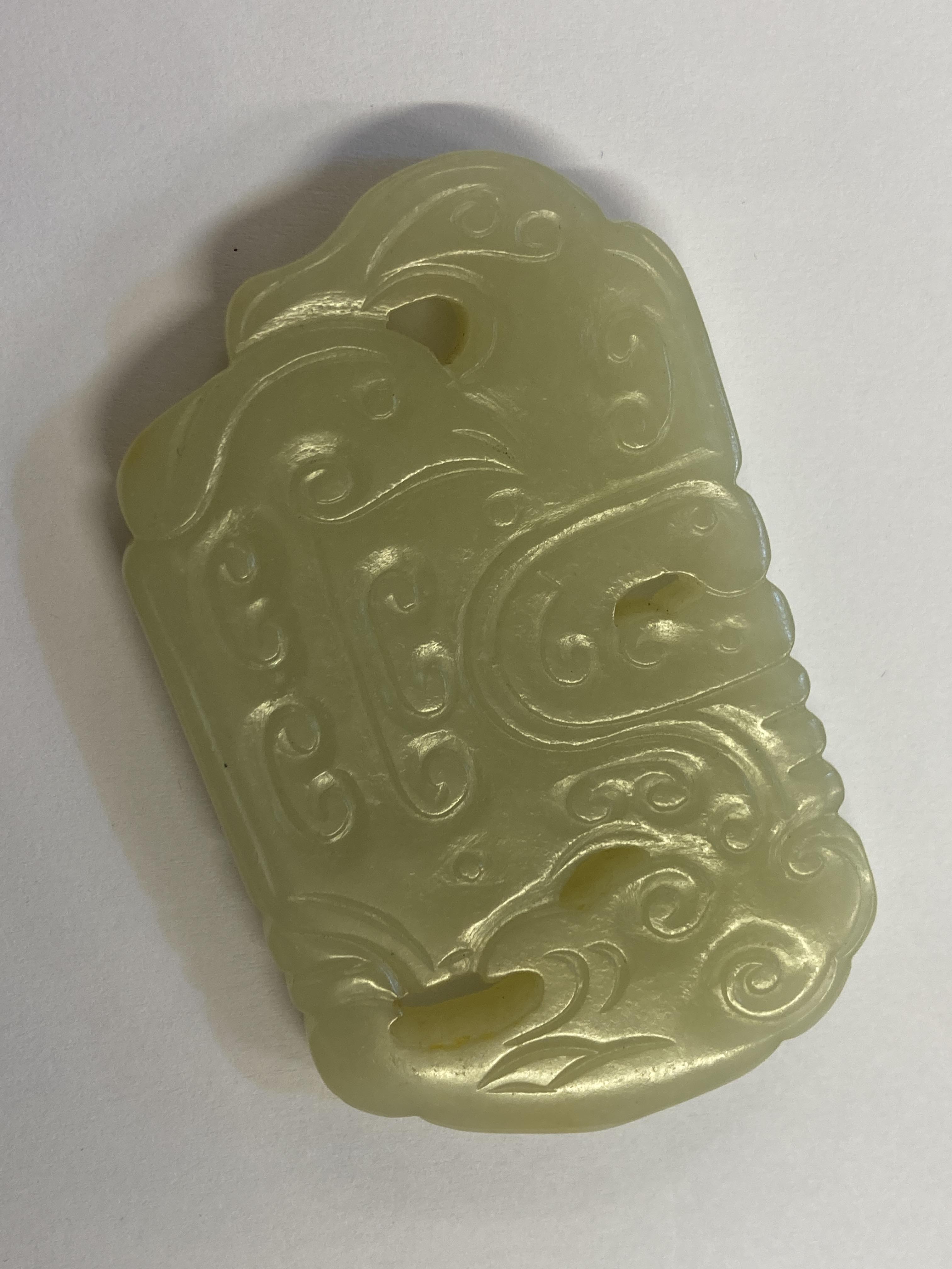Lot 489 - Jade. A Chinese white jade toggle and two
