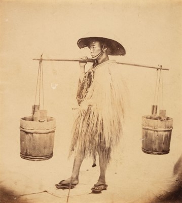 Lot 107 - Japan. A Japanese water carrier in a straw raincoat and hat, c. 1865