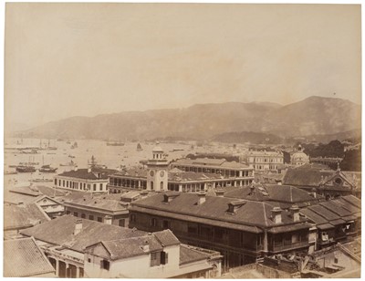 Lot 58 - Hong Kong. A view over the rooftops with an old clock tower and boats in the harbour, c. 1900