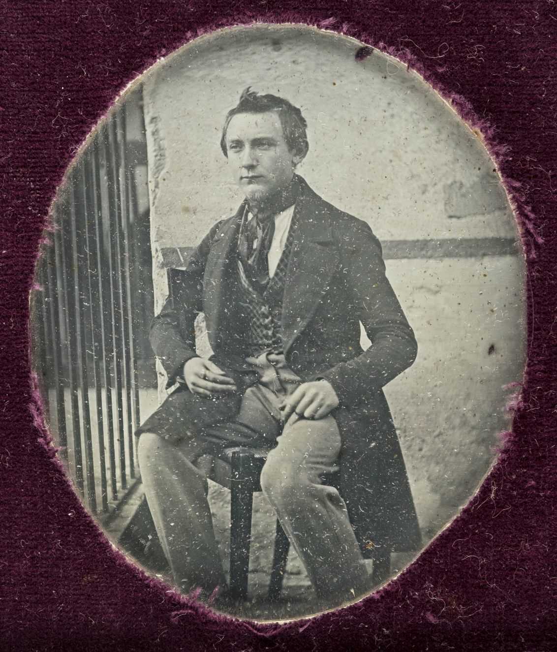 Lot 329 - Sixth-plate daguerreotype of a young man seated outdoors next to railings, by an unknown photographer